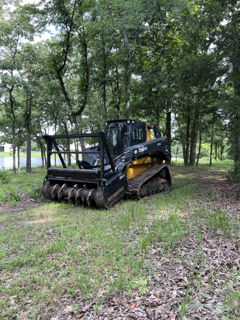 Forestry mulching skid steer clearing wooded land
